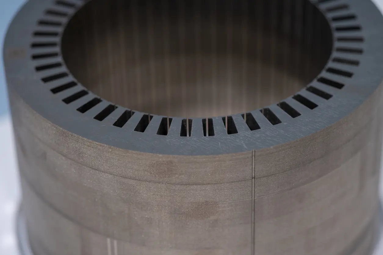 Close-up of an electric motor stator core showing stacked electrical steel laminations.